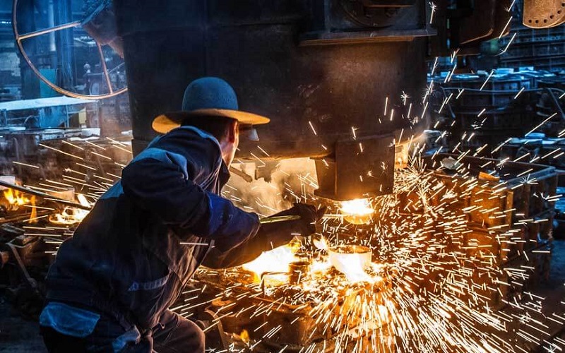 foundry worker pouring metal