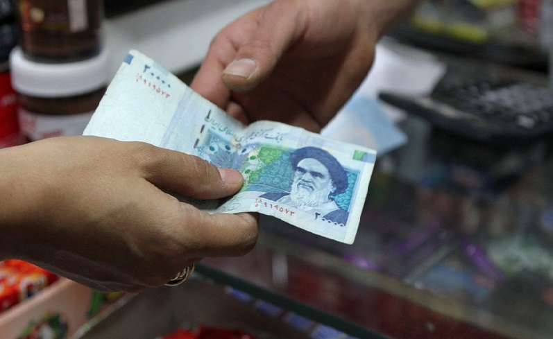 An Iranian woman pays a 20000 rial banknote (around 70 US Cent), bearing a portrait of Iran's late founder of islamic Republic Ayatollah Ruhollah Khomeini, to a grocer in Tehran on September 30, 2012. Iran's currency, the rial has lost over 60 percent of its value since the end of last year, as draconian Western economic sanctions take effect that has spurred already high inflation to even greater heights, with food costs soaring more than 50 percent. AFP PHOTO/ATTA KENARE        (Photo credit should read ATTA KENARE/AFP/GettyImages)